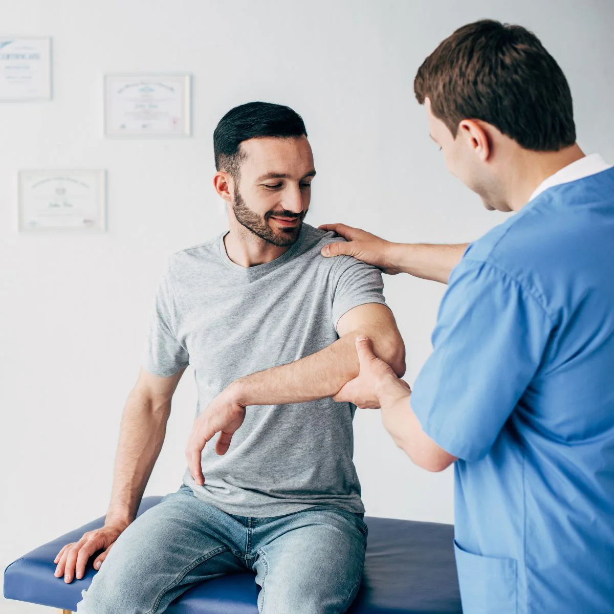 Male patient receiving shoulder examination from doctor