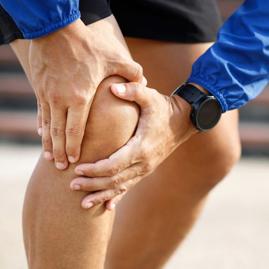 Athlete clutching his knee in pain
