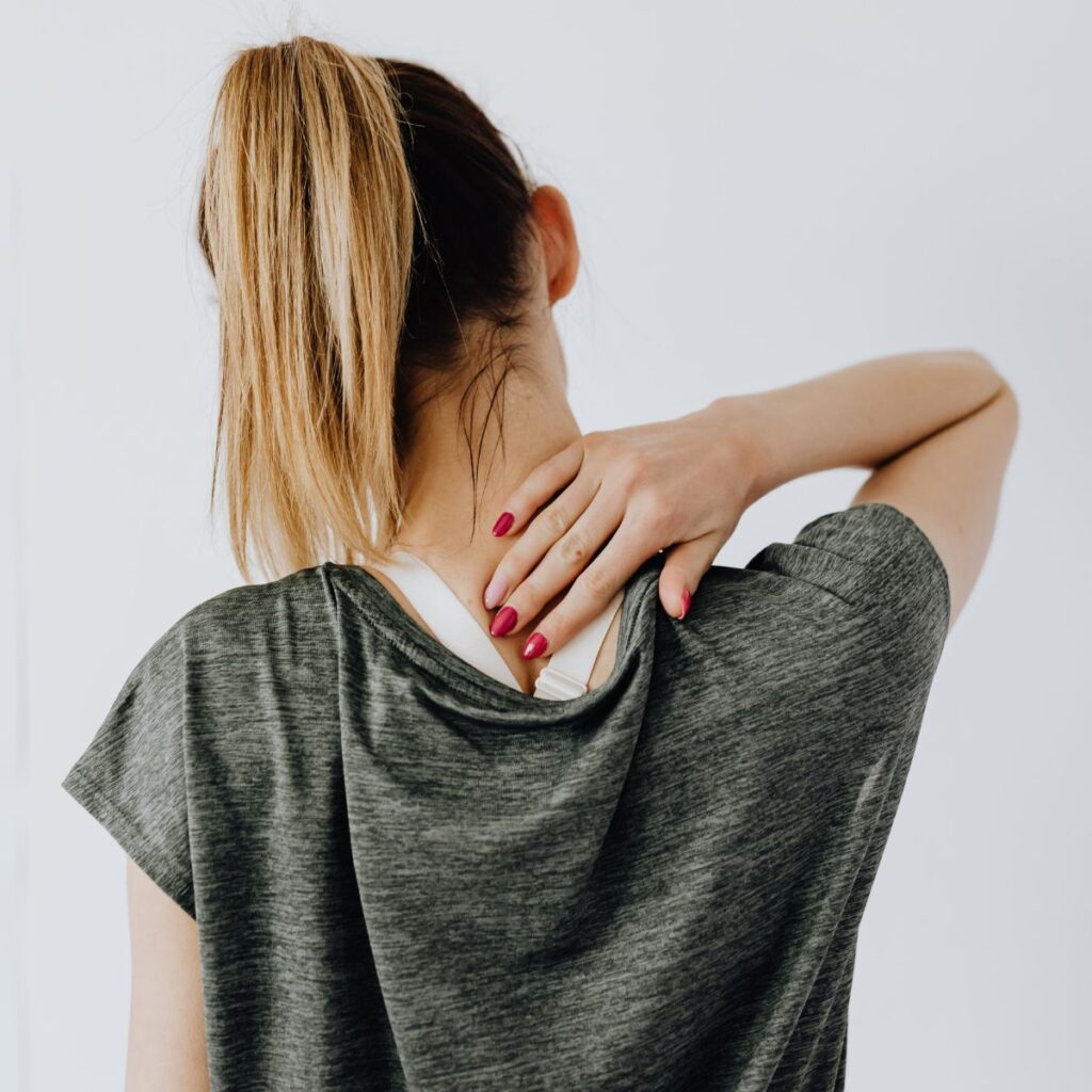 woman with ponytail massaging the back of her neck