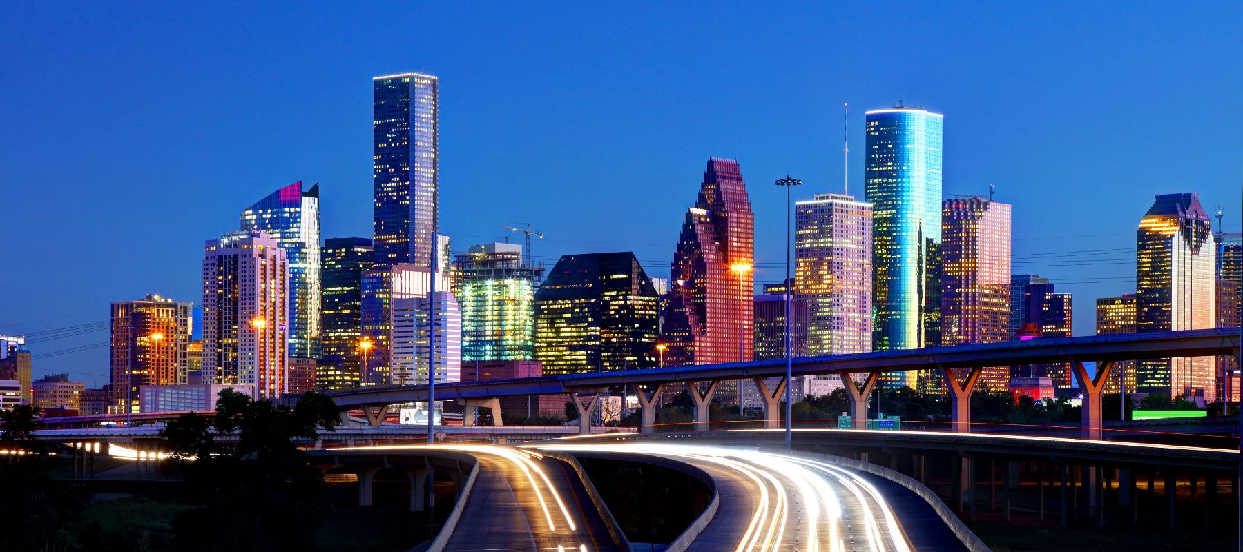 Houston skyline at night with light trails from highway traffic
